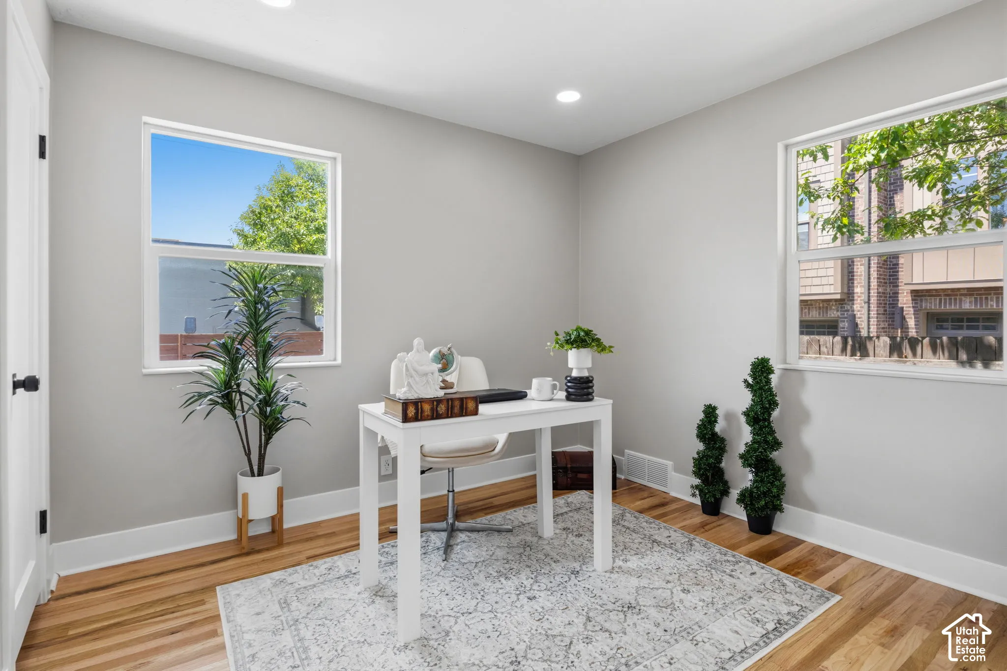 Room with wood-finish flooring, recessed lighting, and dual vinyl-frame windows
