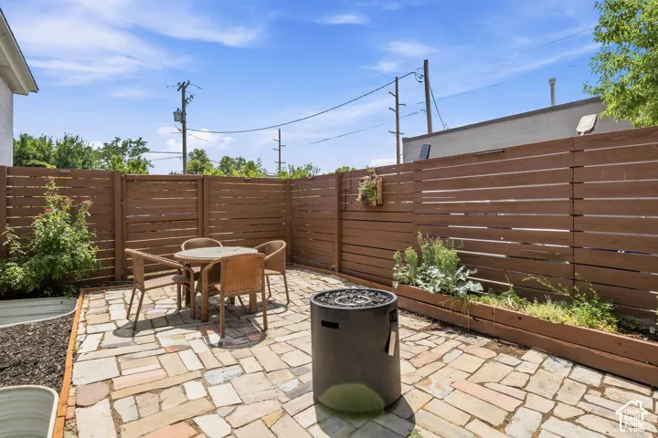 Flagstone patio featuring horizontal wood privacy fencing, built-in planter boxes, and steel-rimmed garden beds