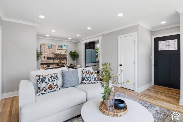 Neutral-toned interior featuring wood-finish flooring, recessed lighting, and a front entry door with a decorative glass panel