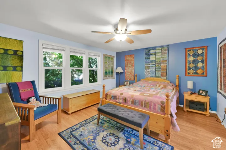 Multi-pane windows, wood-finish flooring, and a ceiling fan with integrated lighting