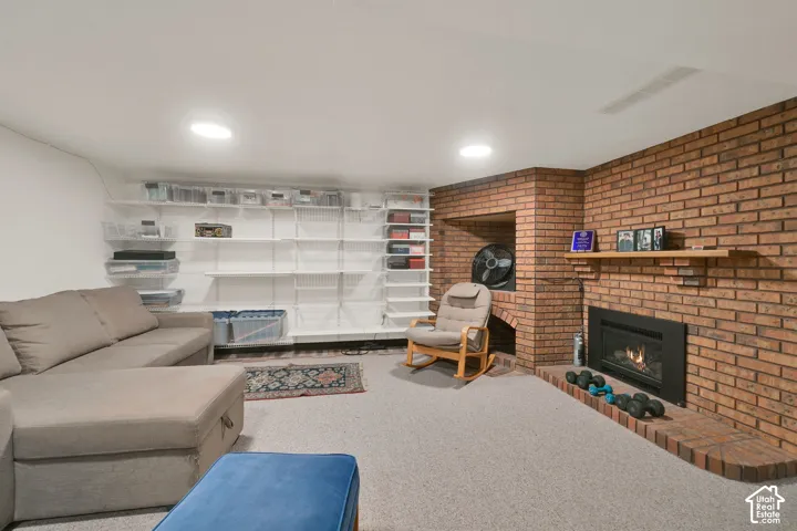 Exposed brick fireplace surround with built-in hearth, insert fireplace, integrated wood mantel, and wall-mounted shelving system