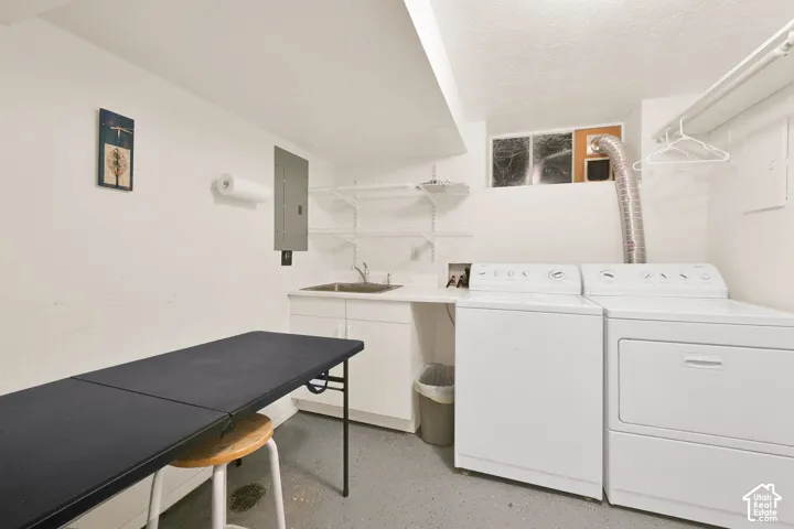 Utility area featuring a stainless steel drop-in sink, white cabinetry, integrated shelving, and a horizontal window
