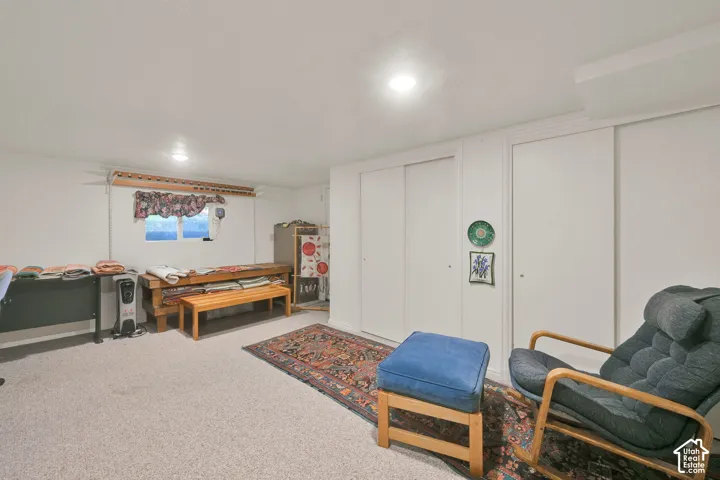Neutral-toned interior space featuring recessed ceiling lighting, wall-to-wall carpeting, and dual sliding-door closets