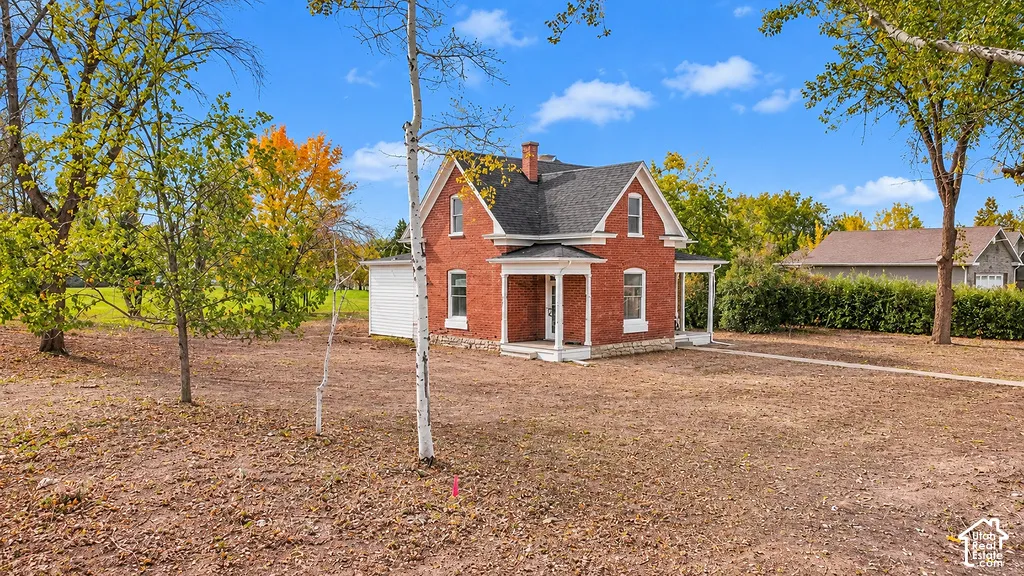 Red brick exterior featuring a steep gabled roof, covered front porch, and tall vertical window placements