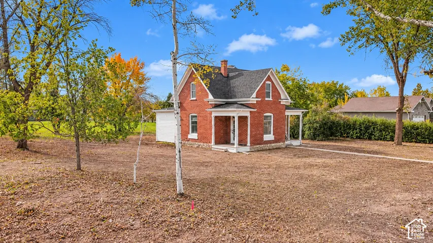 Red brick exterior featuring a steep gabled roof, covered front porch, and tall vertical window placements