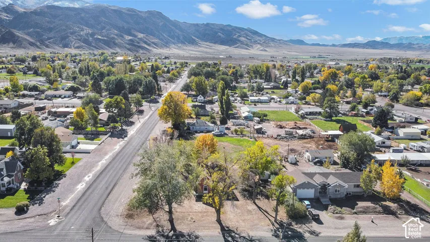 Aerial perspective of property featuring mature trees and mountain range backdrop