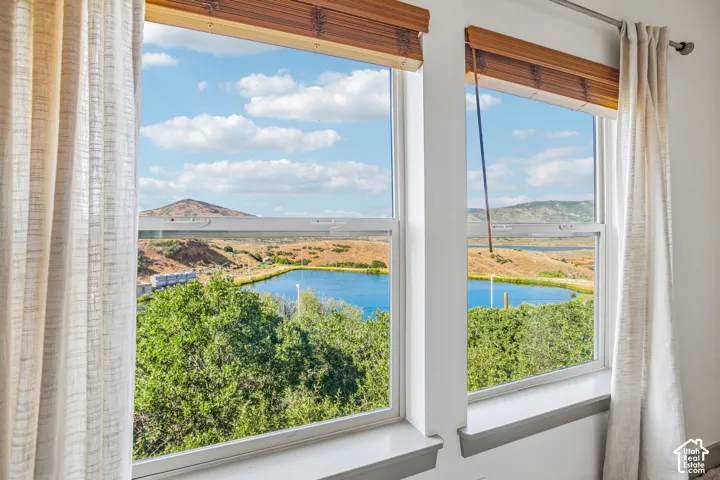Dual double-hung windows with neutral trim, bamboo-style blinds, and mountain and water scenery