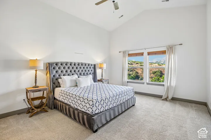 Vaulted ceiling, carpeted flooring, and dual-pane windows with mountain scenery