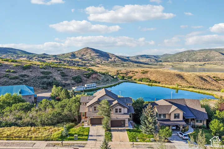 Aerial perspective of multi-story residences featuring multi-pitched rooflines, expansive mountain scenery, and proximity to a central water feature
