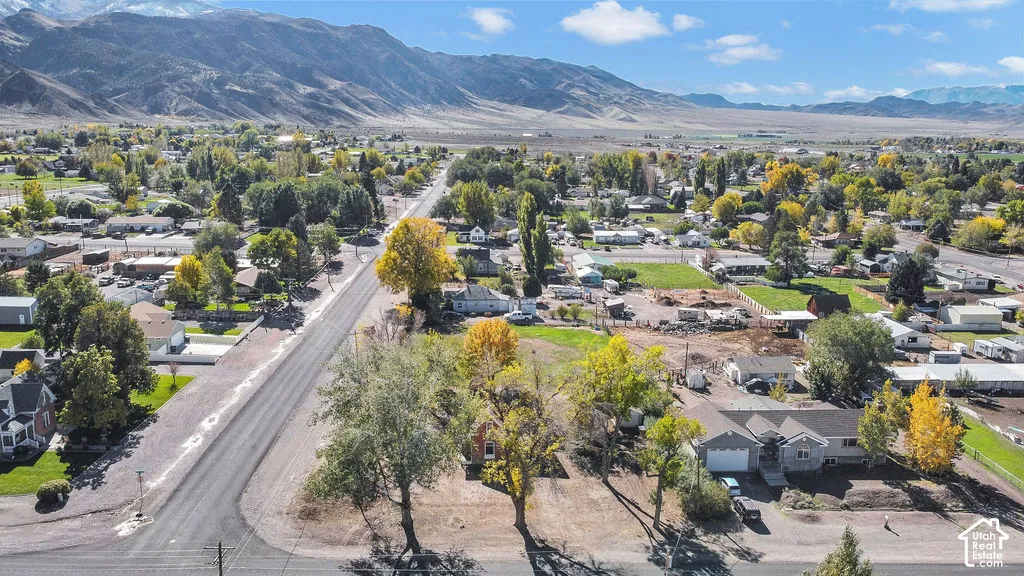 Aerial perspective of property featuring mature trees and mountain range backdrop