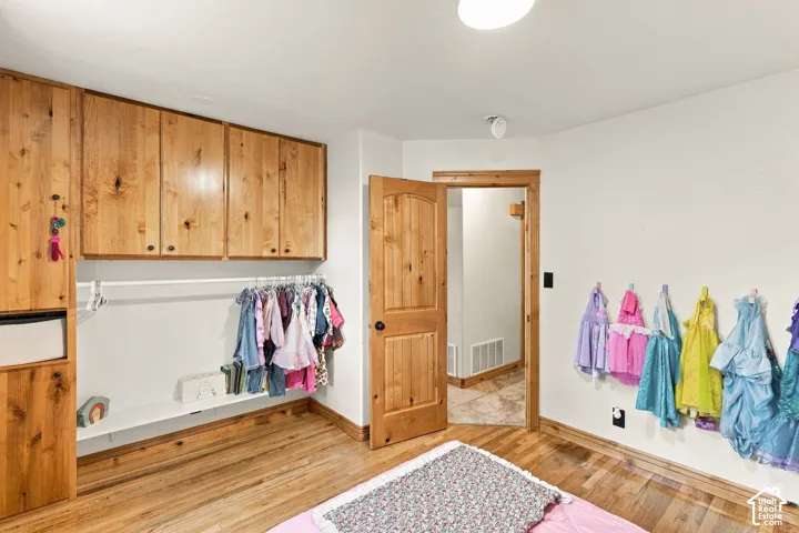 Built-in wood cabinetry, wood-finish flooring, and solid wood interior door with trim