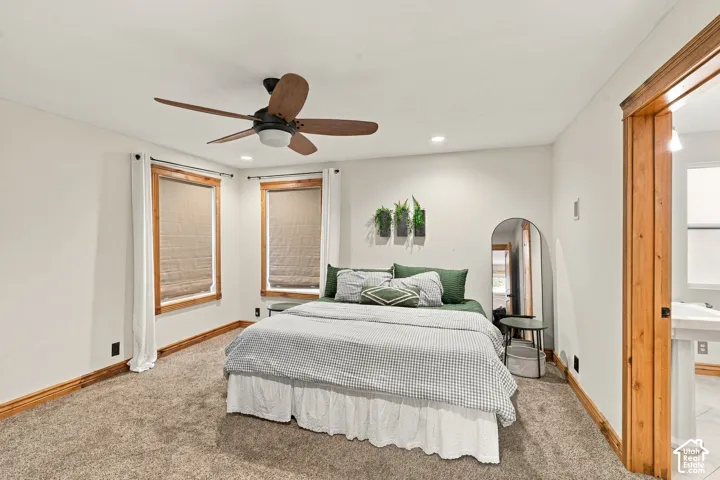 Bedroom featuring neutral carpeting, wood-trimmed windows, recessed lighting, and a multi-blade ceiling fan