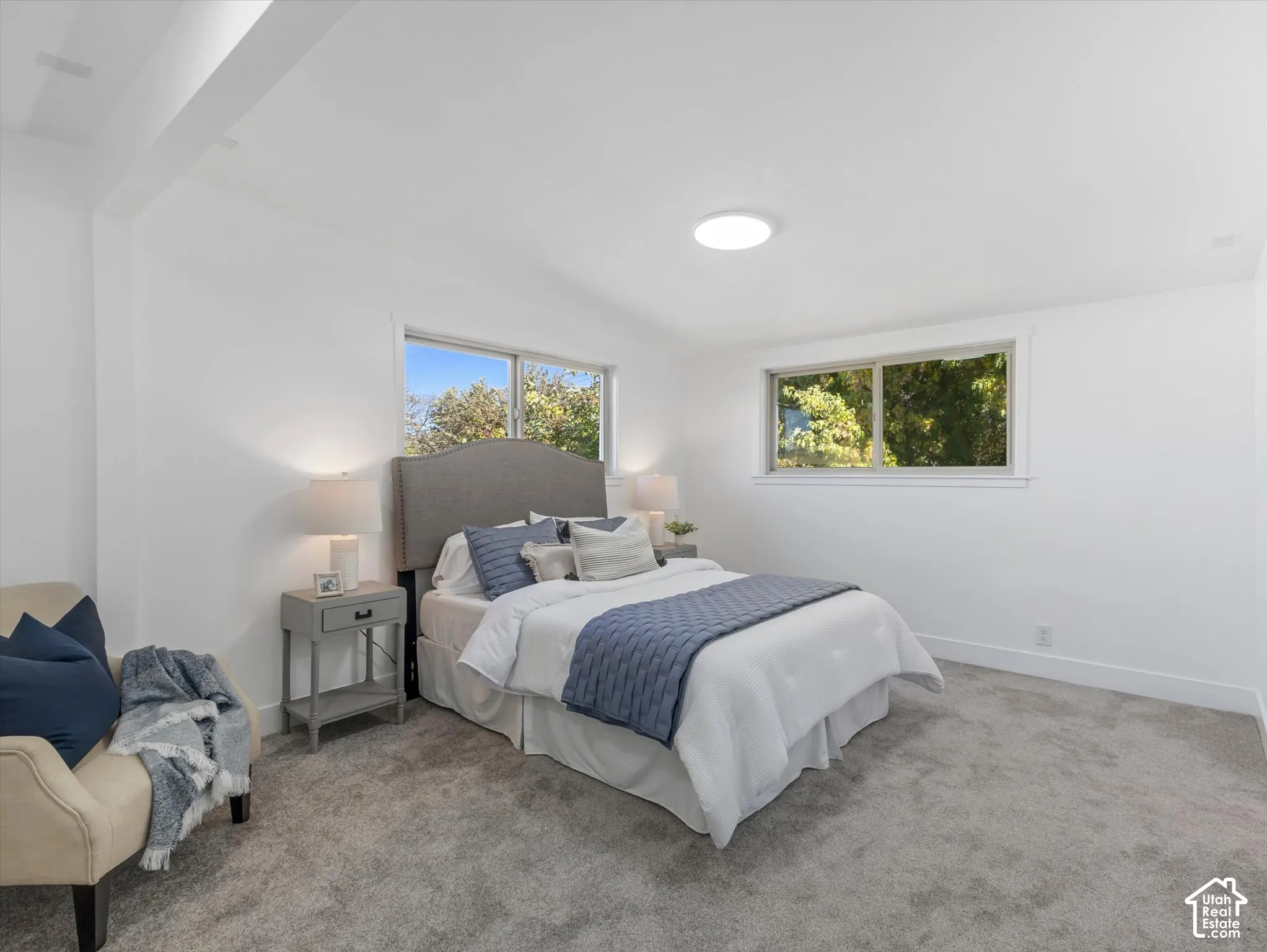 Master Bedroom on the main level with a walk-in closet and Amazing bathroom. Neutral interior space featuring wall-to-wall carpeting, dual windows, and a circular ceiling-mounted light fixture