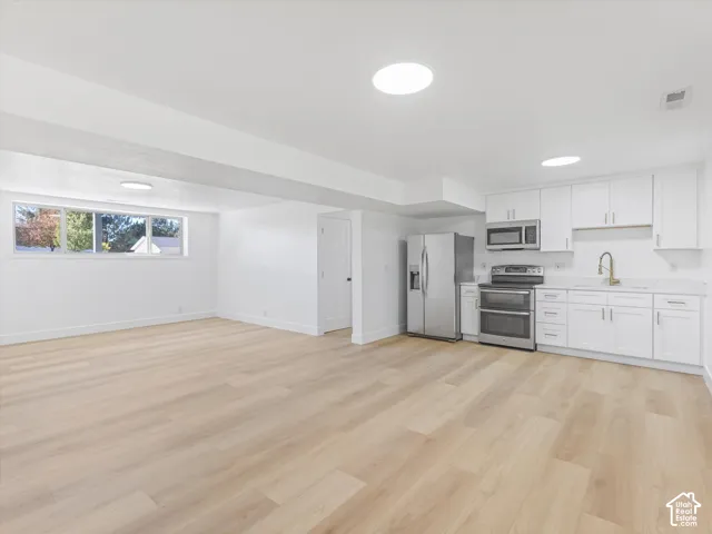 Second Kitchen area featuring white shaker-style cabinetry, stainless steel appliances, wood-finish flooring, and recessed ceiling lighting
