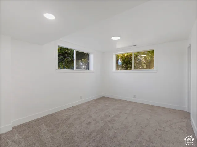 Master Bedroom in basement featuring wall-to-wall carpeting, recessed ceiling lighting, and two sliding windows.