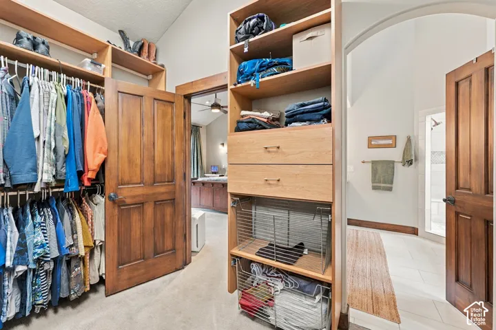 Walk-in closet featuring floor-to-ceiling wooden built-in shelving, integrated dresser drawers, wire storage baskets, and solid wood-finish doors