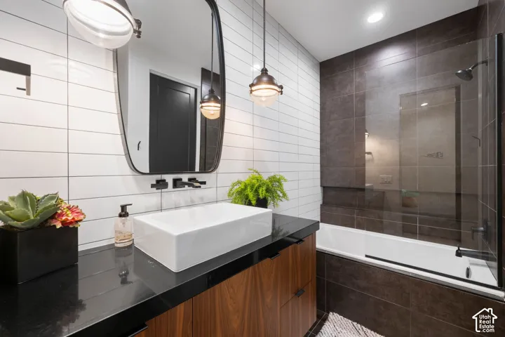 Vanity featuring a rectangular vessel sink, polished stone countertop, and wood-finish cabinetry