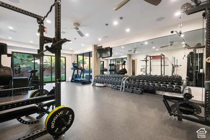 Large-scale wall mirror, expansive rubberized flooring, multi-panel glass door systems, integrated ceiling speakers, and recessed lighting