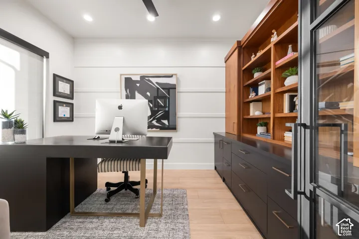 Custom built-in cabinetry featuring wood shelving and matte dark base storage, horizontal shiplap wall detail, wood-finish flooring, and black metal-framed glass doors