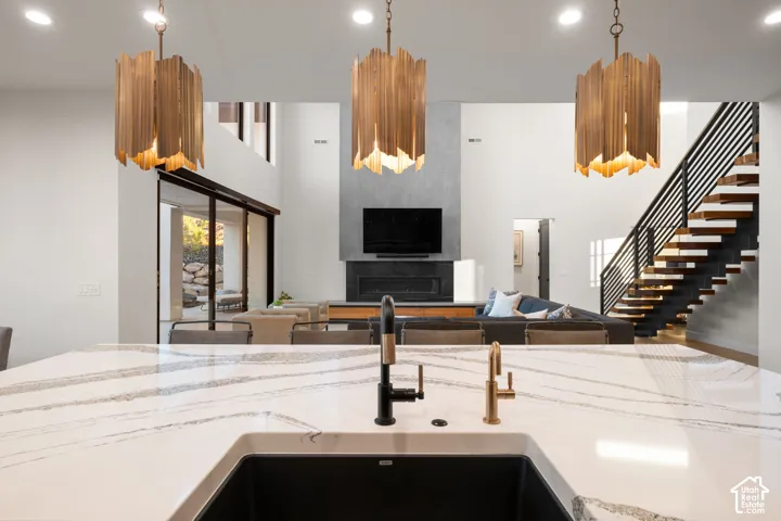Kitchen island featuring a white surface with grey veining, integrated dark basin sink, and dual-finish faucet fixtures