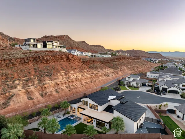 Two-story contemporary residence featuring a metal roof, swimming pool, spa, covered patio, and perimeter wall