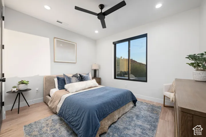 Room featuring wood-finish flooring, recessed lighting, a black ceiling fan, and a black-framed window