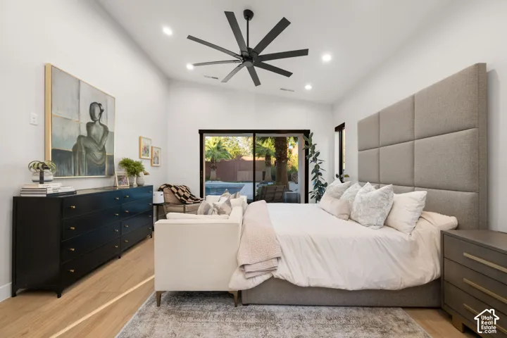 Vaulted ceilings featuring recessed lighting, a modern multi-blade ceiling fan, light-finish wood flooring, and large sliding glass doors