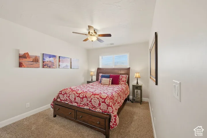 Neutral wall finishes, neutral carpeting, and a ceiling-mounted light fixture with a fan