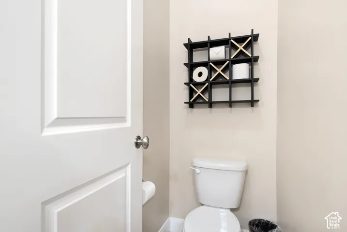 White two-panel interior door with a circular metallic knob and white porcelain toilet