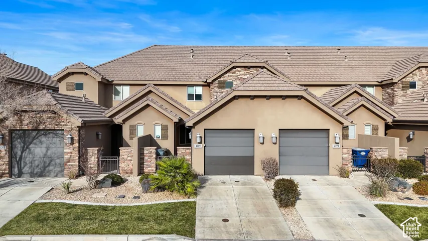 Multi-unit exterior featuring stucco and stone veneer siding, tile roofing, attached garages, and concrete driveways
