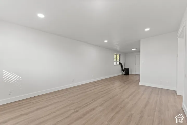 Interior space featuring neutral wall paint, wood-finish flooring, and recessed ceiling lighting