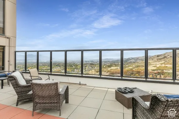 Expansive terrace featuring large-format concrete pavers and a black-framed glass railing