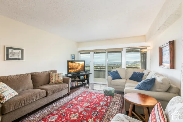 Living area featuring sliding glass doors leading to an exterior balcony and panoramic mountain scenery