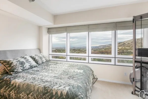 Expansive multi-pane window configuration with integrated fabric Roman shades and elevated mountainous terrain scenery