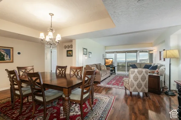 Open-concept interior featuring wood-finish flooring, a multi-arm chandelier, and sliding glass doors with a mountain backdrop
