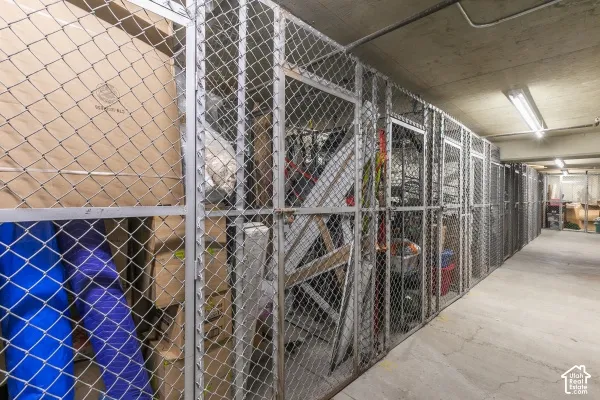 Secured storage area featuring metal chain-link fencing, structural steel frame doors, and concrete flooring