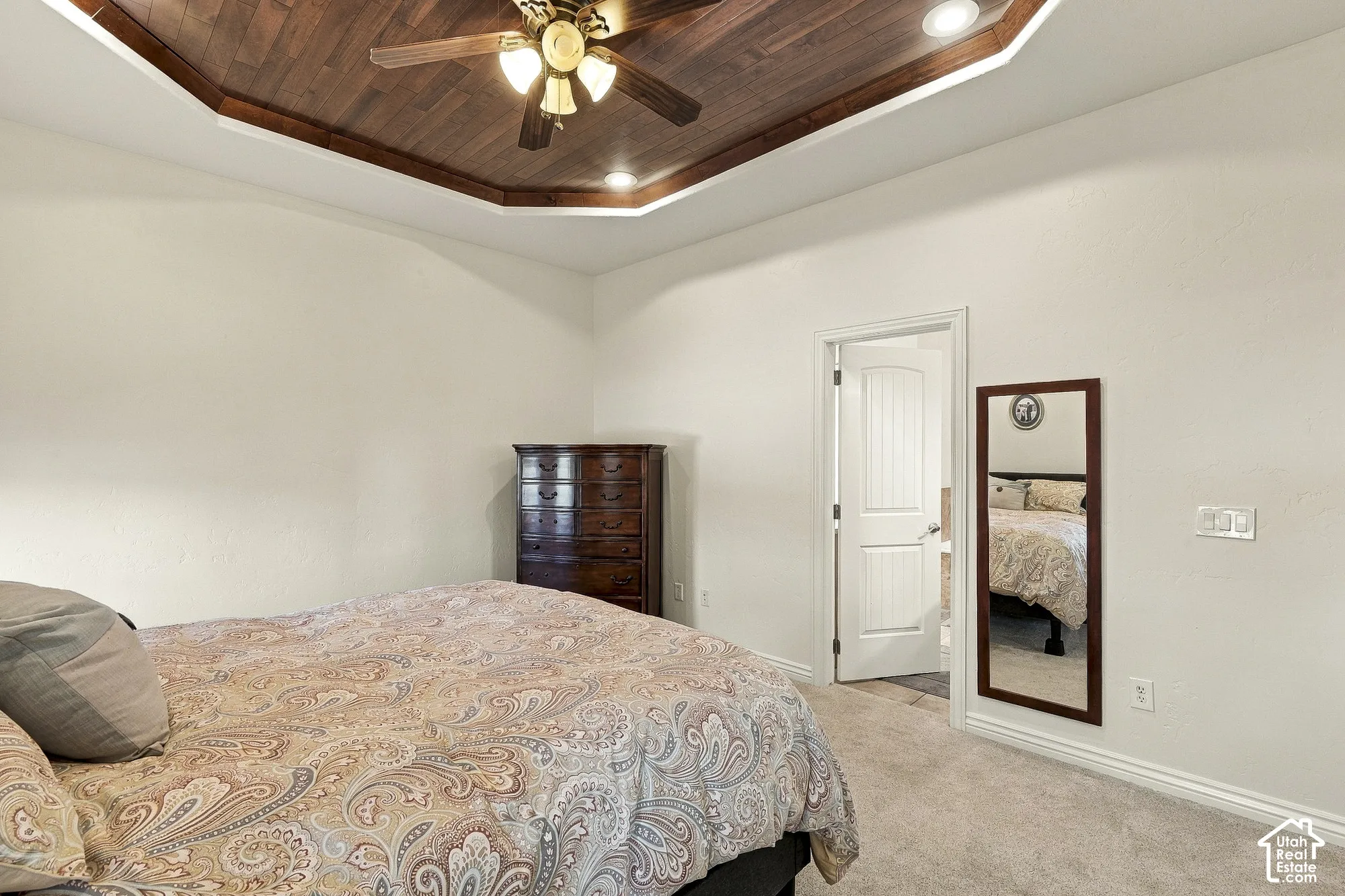 Octagonal tray ceiling with wood-paneling detail, recessed lighting, and a center-mounted ceiling fan