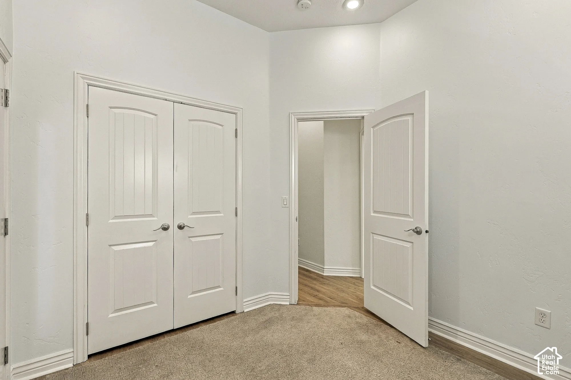Room featuring neutral wall-to-wall carpeting, dual-panel interior doors, and recessed ceiling lighting