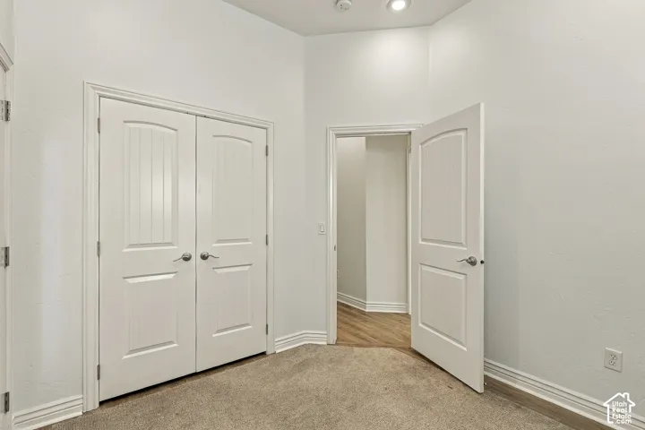 Room featuring neutral wall-to-wall carpeting, dual-panel interior doors, and recessed ceiling lighting
