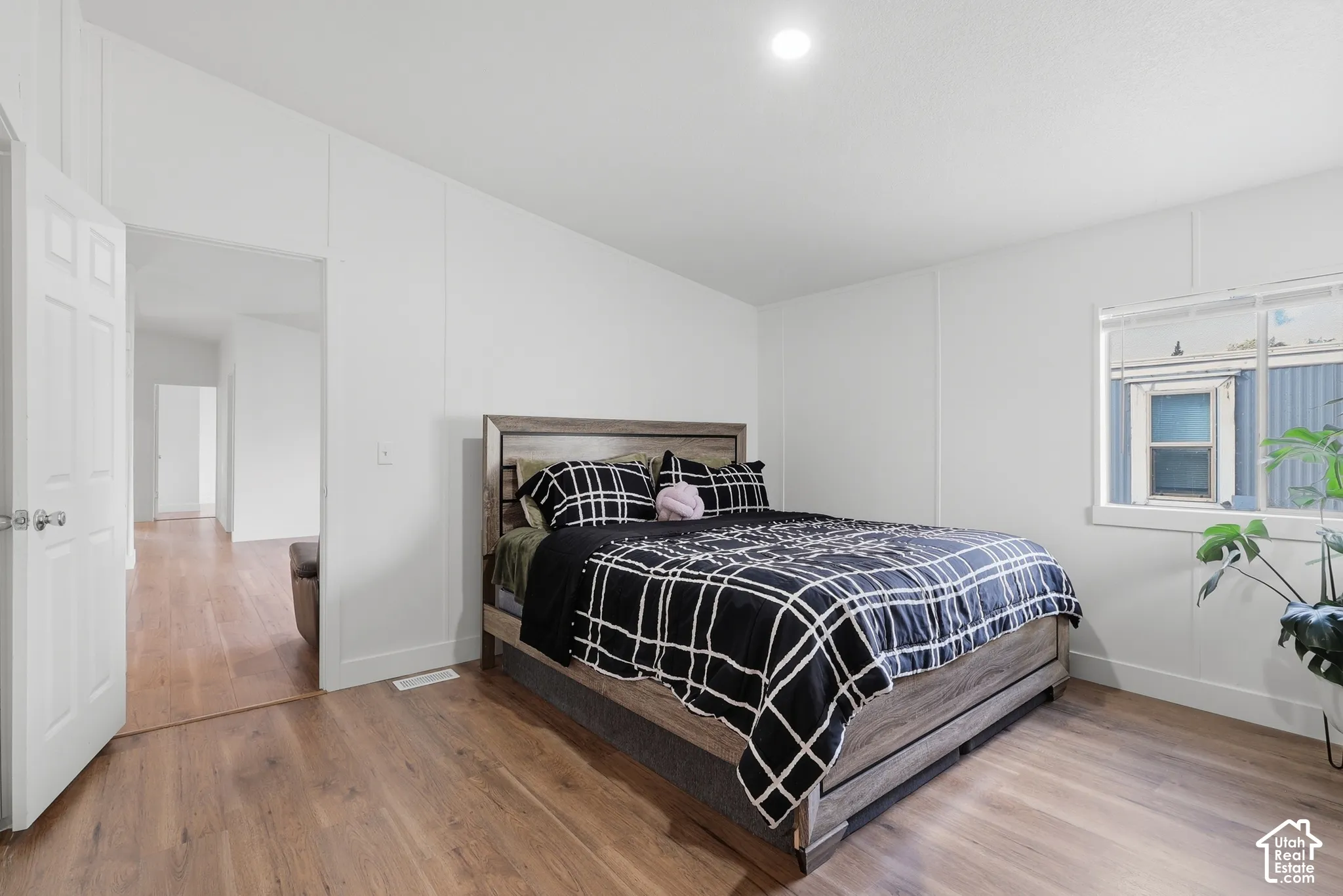 Wood-finish flooring, recessed lighting, and a single-pane window with horizontal blinds