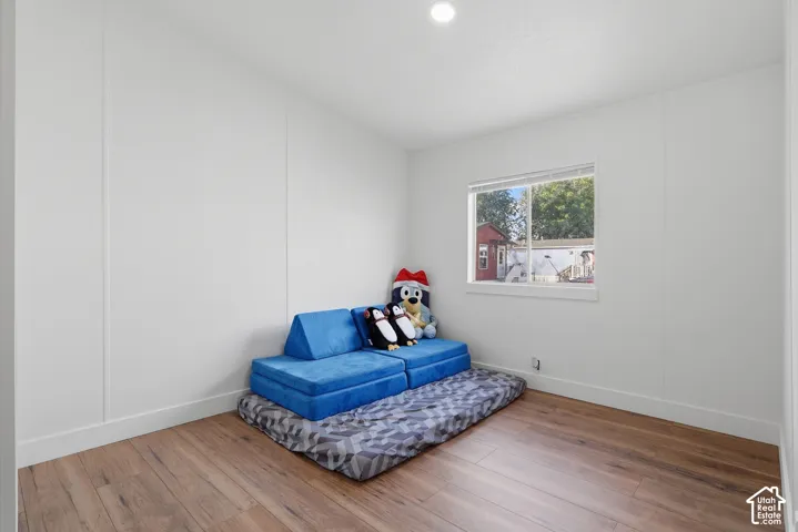 Room featuring wood-finish flooring, crisp white walls, and a recessed ceiling light