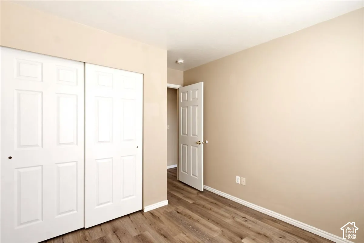 Neutral interior featuring wood-finish flooring and white six-panel doors