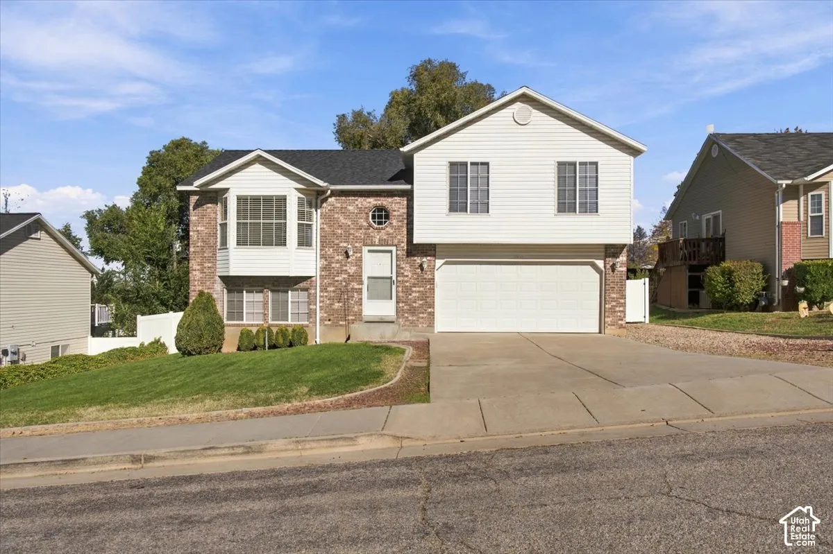 Exterior facade featuring brick masonry and horizontal siding, a gabled roofline, a bay window, and an attached two-car garage