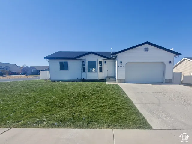 Single-level residence featuring horizontal lap siding, a front-facing attached two-car garage, concrete driveway, and a bay window