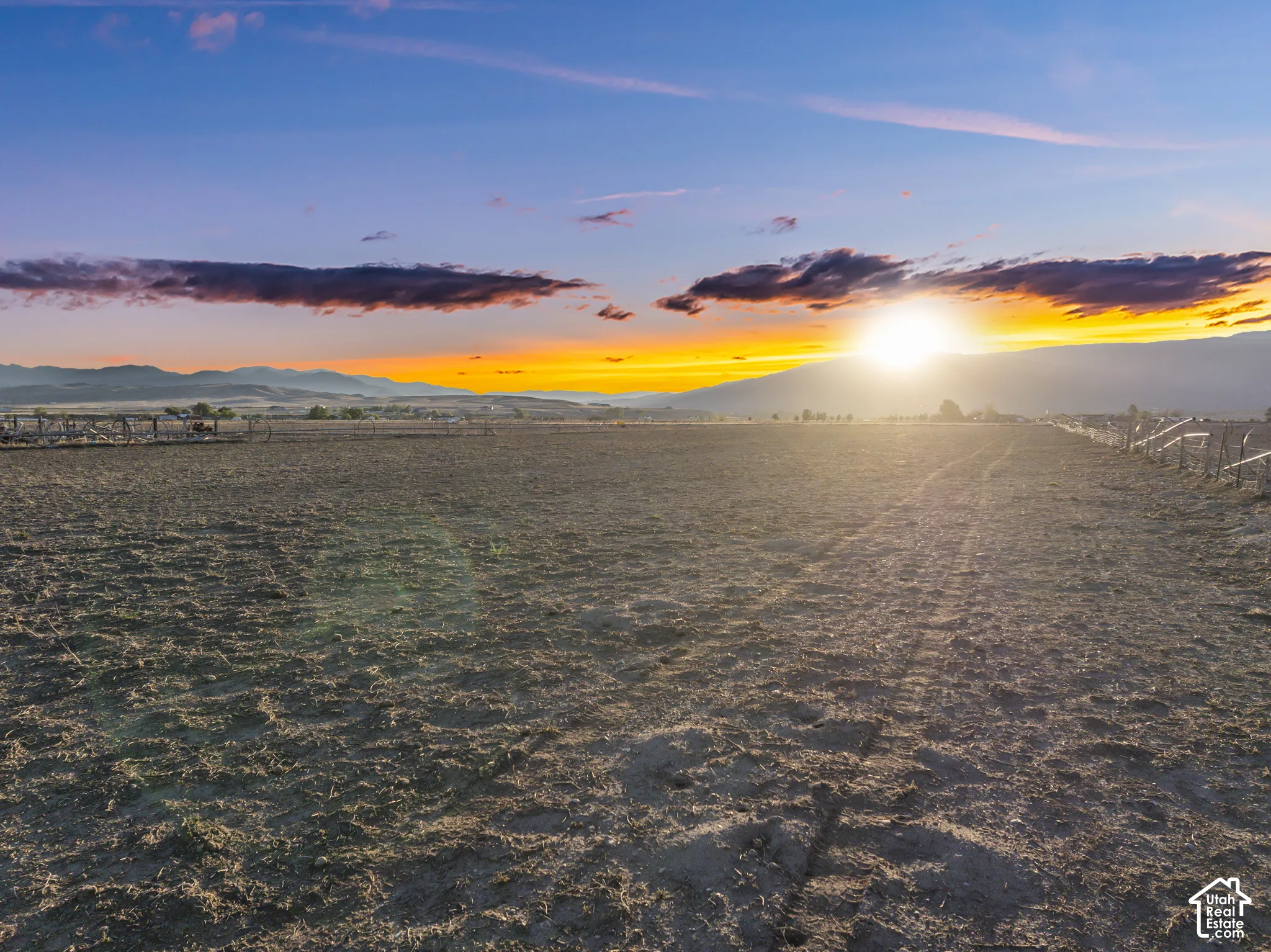 Expansive acreage featuring cleared land, perimeter fencing, and mountain scenery