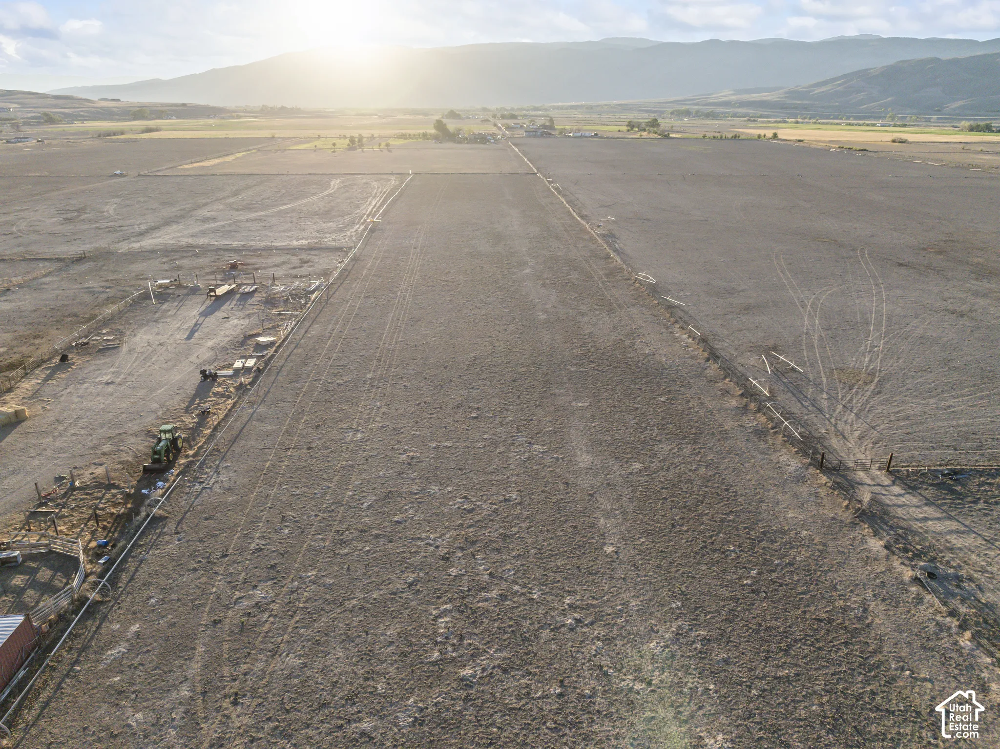 Expansive acreage featuring flat topography, mountain backdrop, and perimeter fencing