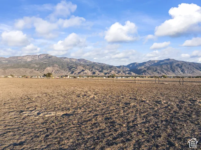 Expansive acreage featuring prominent mountain backdrop and functional irrigation infrastructure