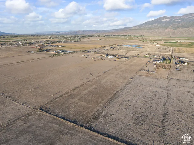 Expansive acreage featuring flat, open terrain, perimeter fencing, and prominent mountain backdrops