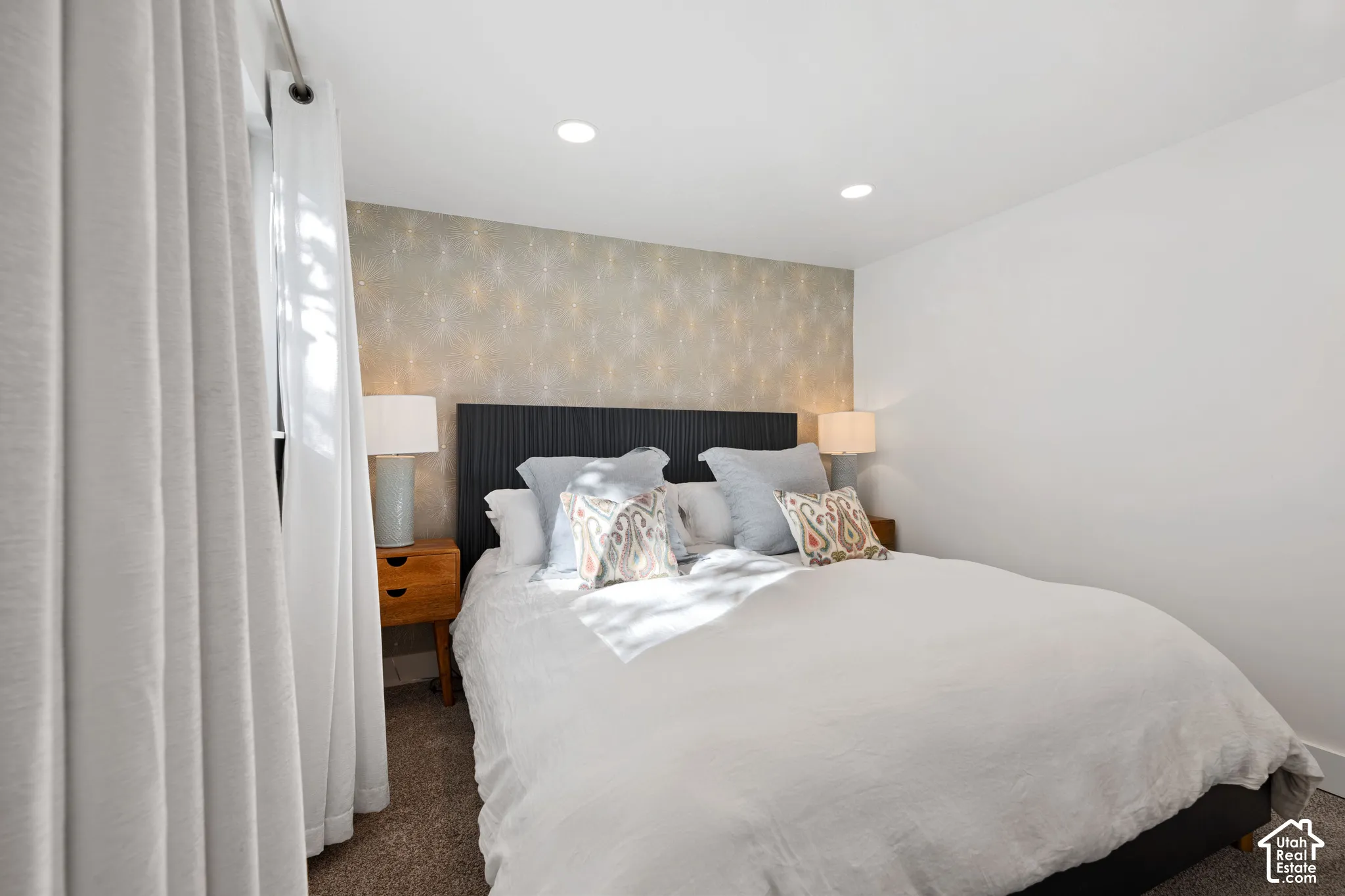 Bedroom featuring an accent wall with patterned wallpaper, recessed lighting, and wall-to-wall carpeting