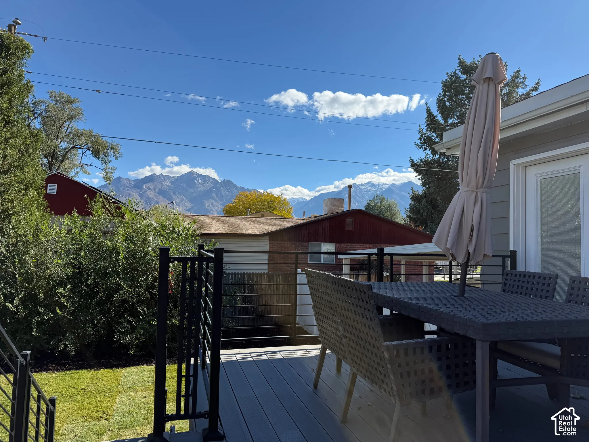 Elevated composite deck featuring a matte black metal railing and mountain scenery backdrop